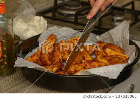 Potato Wedges Before Baking Lined on Parchment Covered Tray Potato Wedges Before Baking Lined on Parchment Covered Tray 137033063