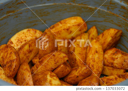 Bowl of Seasoned Potato Wedges Ready for Oven Baking Bowl of Seasoned Potato Wedges Ready for Oven Baking 137033072
