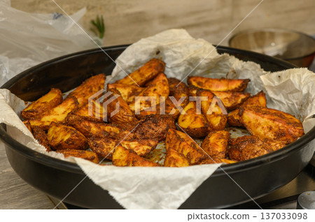 Crispy Baked Potato Wedges with Fresh Rosemary Garnish Crispy Baked Potato Wedges with Fresh Rosemary Garnish 137033098