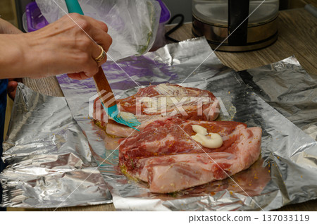 Raw Pork Ribs Basted with Barbecue Sauce on Foil Raw Pork Ribs Basted with Barbecue Sauce on Foil 137033119