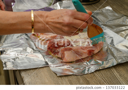 Applying Spicy Glaze to Raw Pork Ribs Before Roasting 137033122