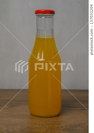 Bottle of Orange Juice on Wooden Table Natural Setting 137033204