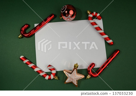 Christmas Decorations Around Blank Card on Festive Green Background Christmas Decorations Around Blank Card on Festive Green Background 137033230
