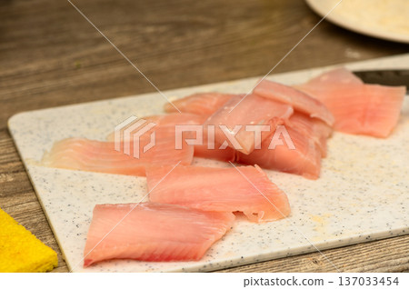 Raw Tilapia Fillet Pieces on Plastic Cutting Board Raw Tilapia Fillet Pieces on Plastic Cutting Board 137033454