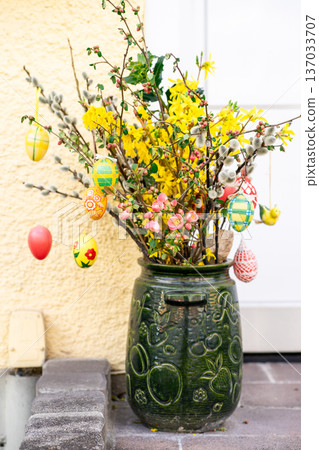 Bright spring bouquet with forsythia, willow branches and painted eggs in decorative ceramic pot. Traditional Easter decor and seasonal celebration. Bright spring bouquet with forsythia, willow branches and painted eggs in decorative ceramic pot. Traditional Easter decor and seasonal celebration. 137033707