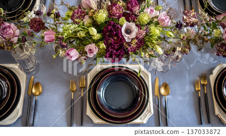 Elegant table setting for a special event with blooming floral centerpiece, luxurious black and gold flatware 137033872