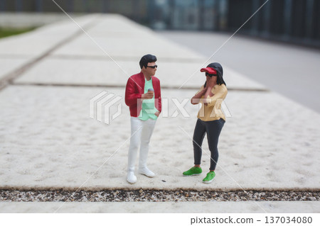 Miniature figures engage in conversation on raised outdoor platform Miniature figures engage in conversation on raised outdoor platform 137034080