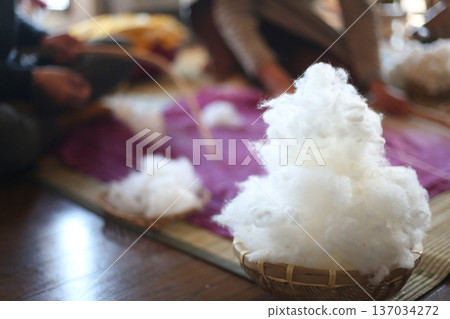 A woman shooting cotton with a cotton bow 137034272