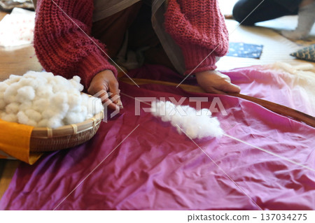 A woman shooting cotton with a cotton bow 137034275