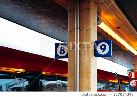 Train platforms numbered eight and nine at a busy train station during the day Train platforms numbered eight and nine at a busy train station during the day 137034342
