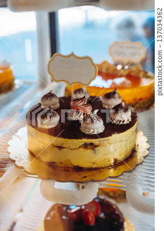 Sweet dessert display with layered cake and cream toppings in a bakery setting 137034362