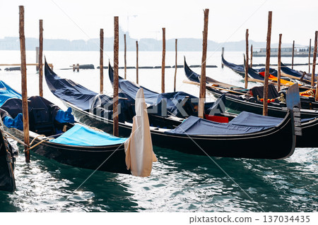 Gondolas in a quiet waterfront at sunset in a historic city Gondolas in a quiet waterfront at sunset in a historic city 137034435