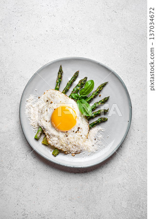 Fried egg with green asparagus and grated parmesan cheese for healthy breakfast 137034672
