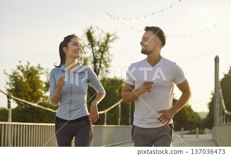 Happy sporty couple family running together, man, woman jogging on park path, enjoy shared exercise Happy sporty couple family running together, man, woman jogging on park path, enjoy shared exercise 137036473