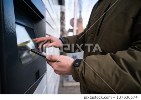 Man Picking Up A Parcel From Parcel Automated Locker 137036574
