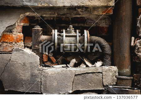 Broken Pipe And Large Shut-Off Valve In Old Wall Broken Pipe And Large Shut-Off Valve In Old Wall 137036577