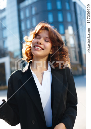 Smiling Beautiful Businesswoman With Closed Eyes In Warm Light Smiling Beautiful Businesswoman With Closed Eyes In Warm Light 137036609