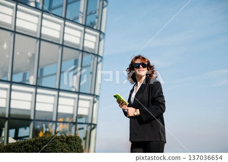 Businesswoman In Sunglasses Talking On Phone In City Business District 137036654