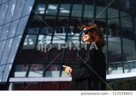 Confident Businesswoman Walking Near Corporate Office Building Outdoors Confident Businesswoman Walking Near Corporate Office Building Outdoors 137036661