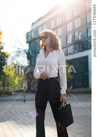 Smiling Businesswoman With Sunglasses Enjoying Urban Sunlight Outdoors 137036689