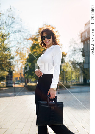 Confident Businesswoman Standing In Sunglasses Near Glass Office Architecture Confident Businesswoman Standing In Sunglasses Near Glass Office Architecture 137036695