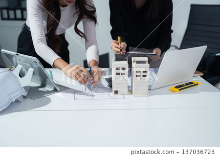 architect asian woman working with colleagues project at construction site at desk in office. 137036723