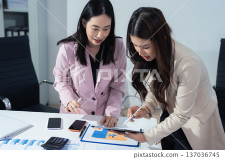 Businessmen team or financial data analysts working with tablets and laptop computers and data graphs together. Plan to analyzing projects in the office. 137036745
