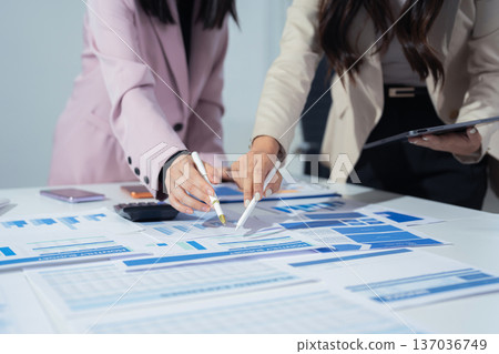 Businessmen team or financial data analysts working with tablets and laptop computers and data graphs together. Plan to analyzing projects in the office. Businessmen team or financial data analysts working with tablets and laptop computers and data graphs together. Plan to analyzing projects in the office. 137036749
