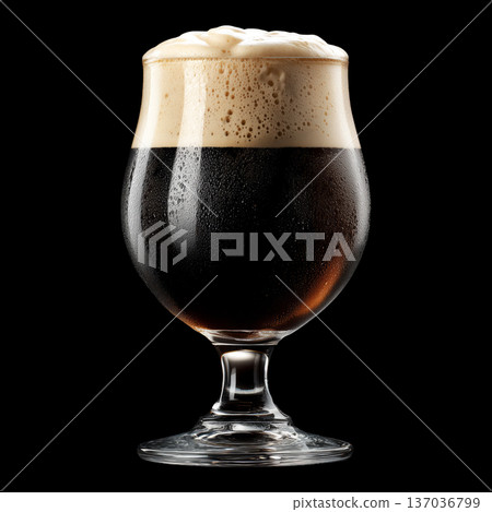 Foamy dark stout beer in a pint tulip glass with creamy foam head, isolated on black background, concept of refreshment and taste 137036799