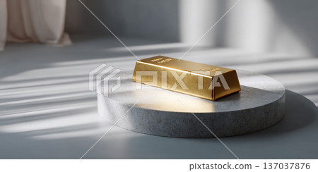 Single gold bar placed on round stone pedestal with soft natural light and shadows in minimalist setting 137037876