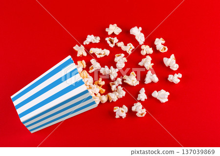 box with popcorn striped in different colors on a red background box with popcorn striped in different colors on a red background 137039869