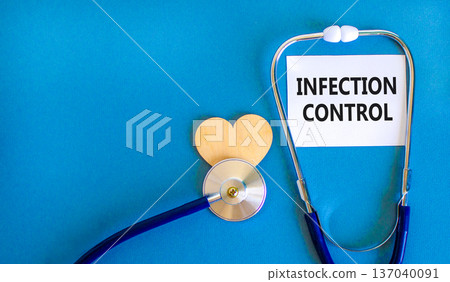 Infection control symbol. Concept words Infection control on beautiful white card. Wooden heart and stethoscope. Beautiful blue background. Medical healthy lifestyle infection control concept. Infection control symbol. Concept words Infection control on beautiful white card. Wooden heart and stethoscope. Beautiful blue background. Medical healthy lifestyle infection control concept. 137040091