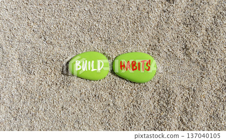 Build habits symbol. Concept word Build habits on beautiful green stones. Sea sand beach. Beautiful sand beach background. Business build habits concept. Copy space. Build habits symbol. Concept word Build habits on beautiful green stones. Sea sand beach. Beautiful sand beach background. Business build habits concept. Copy space. 137040105