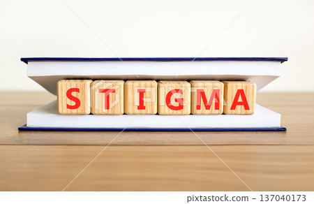 Stigma word symbol. Concept word Stigma on beautiful wooden blocks in beautiful book. Beautiful wooden table white background. Business psychological stigma word concept. Copy space. Stigma word symbol. Concept word Stigma on beautiful wooden blocks in beautiful book. Beautiful wooden table white background. Business psychological stigma word concept. Copy space. 137040173