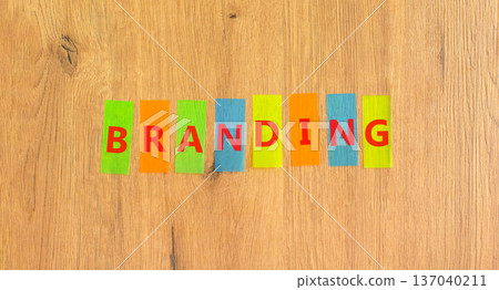 Branding brand word symbol. Concept word Branding on beautiful colored papers. Beautiful wooden background. Business support help branding brand word concept. Copy space. Branding brand word symbol. Concept word Branding on beautiful colored papers. Beautiful wooden background. Business support help branding brand word concept. Copy space. 137040211