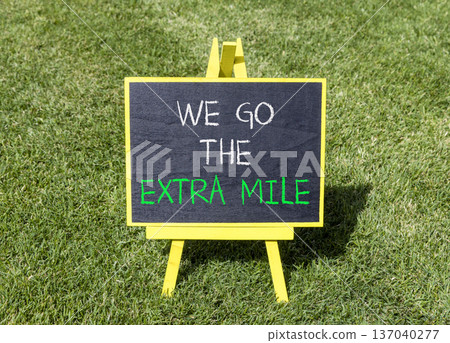 Support, help we go the extra mile symbol. Concept words We go the extra mile on beautiful blackboard. Beautiful green grass lawn background. Business we go the extra mile concept. Copy space. Support, help we go the extra mile symbol. Concept words We go the extra mile on beautiful blackboard. Beautiful green grass lawn background. Business we go the extra mile concept. Copy space. 137040277