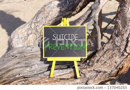 Suicide prevention symbol. Concept words Suicide prevention on beautiful black yellow blackboard. Beautiful old wood and sand background. Psychological and suicide prevention concept. Copy space. 137040283