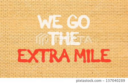 Support, help we go the extra mile symbol. Concept words We go the extra mile on beautiful brown brick wall. Beautiful brick wall background. Business we go the extra mile concept. Copy space. 137040289