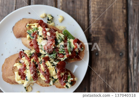 Baguette toast topped with scrambled eggs and spinach Baguette toast topped with scrambled eggs and spinach 137040318