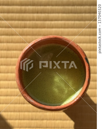 在榻榻米房間裡,人們正在用茶碗沖泡抹茶。 在榻榻米房間裡,人們正在用茶碗沖泡抹茶。 137040320