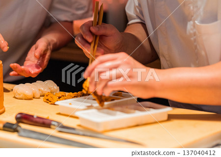 Skilled chef preparing sushi with fresh ingredients and precise techniques Skilled chef preparing sushi with fresh ingredients and precise techniques 137040412