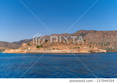 Historic fortress on Spinalonga Island in Crete, Greece under clear blue skies Historic fortress on Spinalonga Island in Crete, Greece under clear blue skies 137040584