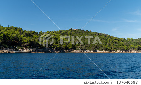 Beautiful clear waters and lush greenery surround the rocky coastline of Lokrum Island. Beautiful clear waters and lush greenery surround the rocky coastline of Lokrum Island. 137040588