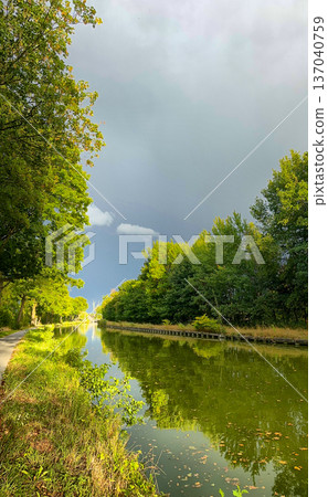 Stormy sky scene, Overcast skies cast shadows on tranquil water Stormy sky scene, Overcast skies cast shadows on tranquil water 137040759
