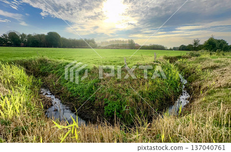 Pastoral landscape featuring flowing twin streams and distant horizon 137040761