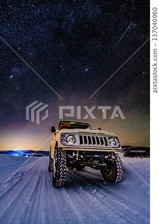 冬日繁星點點的夜空,一輛四輪傳動車行駛在積雪覆蓋的道路上。夜色中,一顆流星劃過夜空。 冬日繁星點點的夜空,一輛四輪傳動車行駛在積雪覆蓋的道路上。夜色中,一顆流星劃過夜空。 137040960