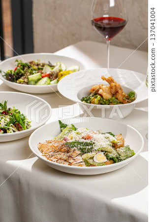 Assorted restaurant dishes with glass of wine Assorted restaurant dishes with glass of wine 137041004