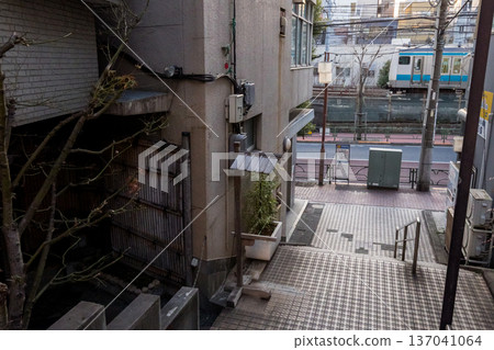 [Keihin-Tohoku Line] A local train passing through a shopping district early in the morning 137041064