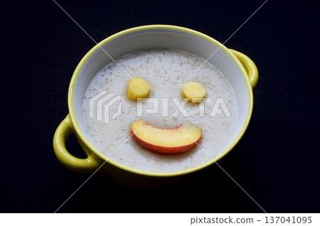 Oatmeal with ripe peach slices arranged in a smiley face. 137041095