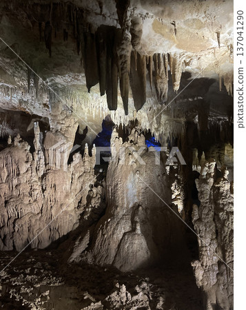 Majestic stalactites and stalagmites in illuminated underground cave 137041290